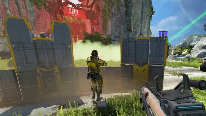 Mirage in Apex Legends fights from behind the cover of his teammate Newcastle’s Shield Wall Ultimate.