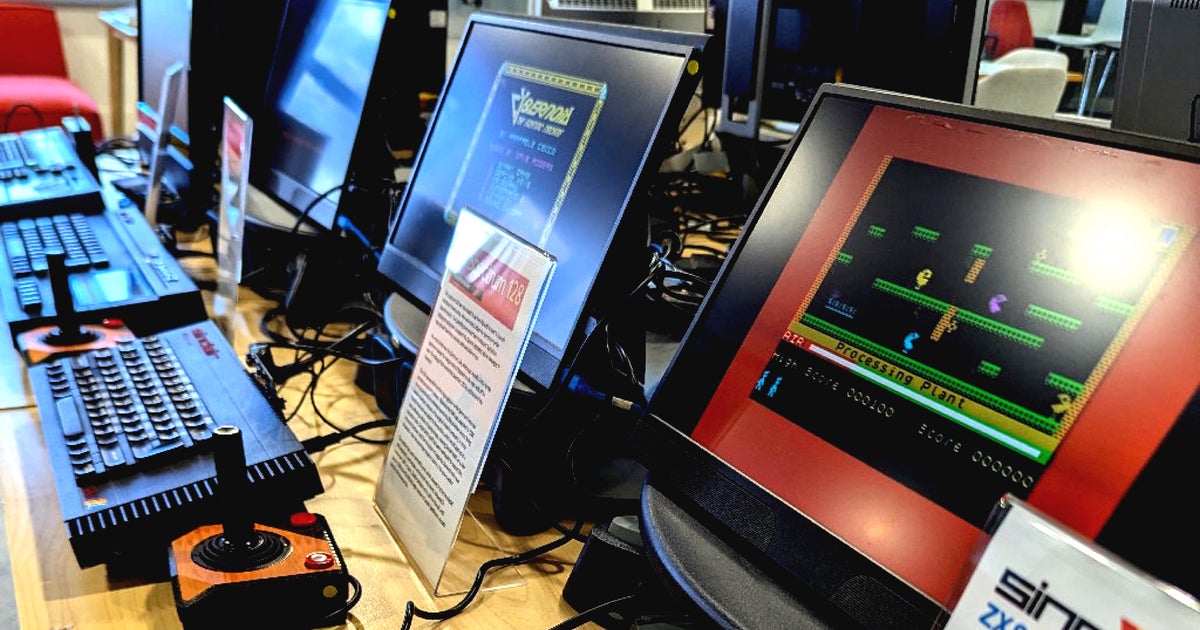 Photograph showing several generations of Spectum home computers running different games on attached monitors.