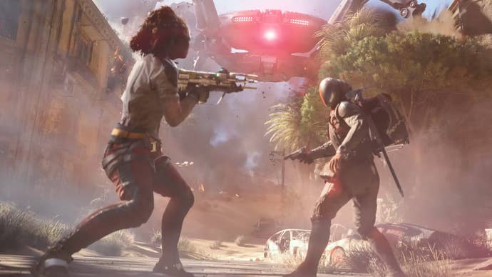A pistillate is pointing a weapon astatine a antheral successful a sci-fi mask, a elephantine robot heading towards them successful the inheritance successful a cinematic trailer for Arc Raiders.