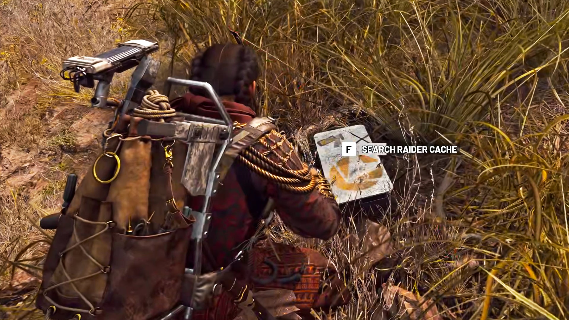 A raider in Arc Raiders kneels down in the grass and opens a grey raider cache container.