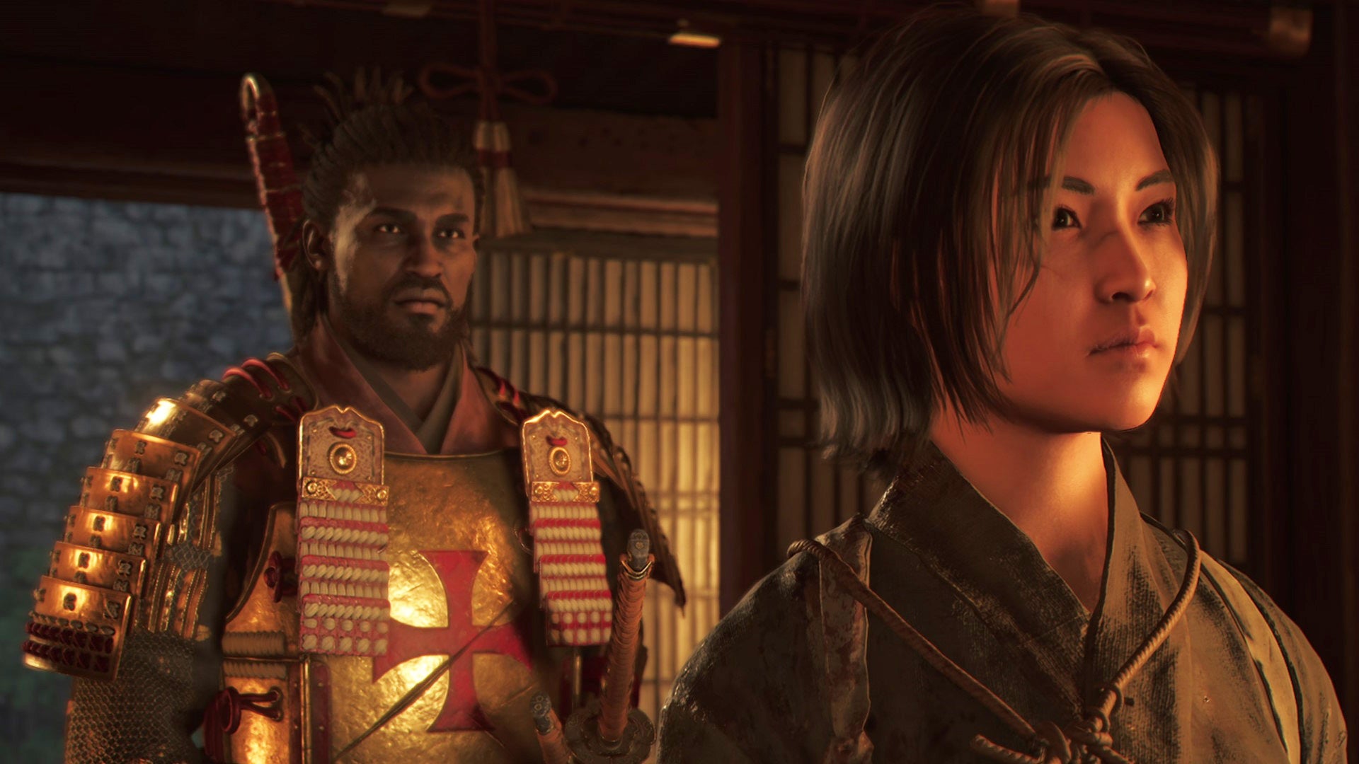 Yasuke and Naoe stand inside a dimly lit room in Assassin&rsquo;s Creed Shadows.