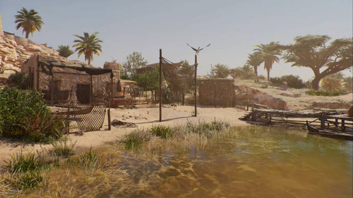 Assassin’s Creed Mirage, landscape shot of fishing huts, nets, and hanging fish on the bank of a River.