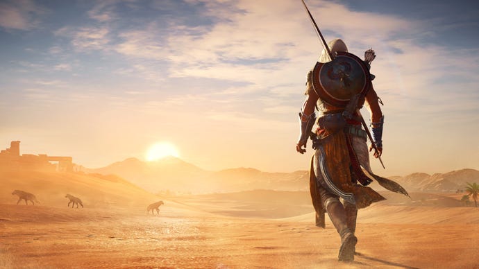 An assassin looks out over a sandy desert in Assassin’s Creed Origins