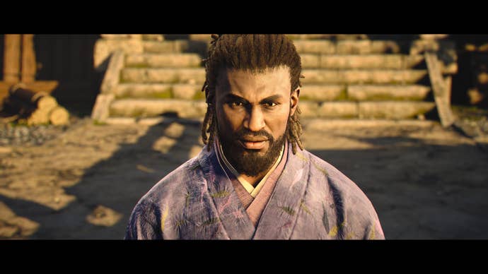 A close-up of Yasuke kneeling while wearing a samurai robe in Assassin’s Creed Shadows.