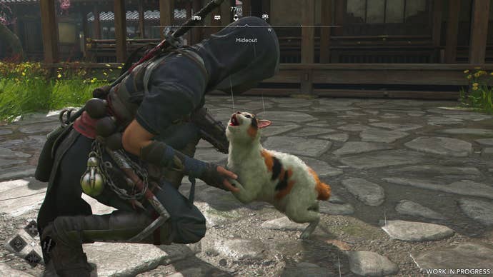 A female shinobi pets a cat in Assassin’s Creed Shadows.
