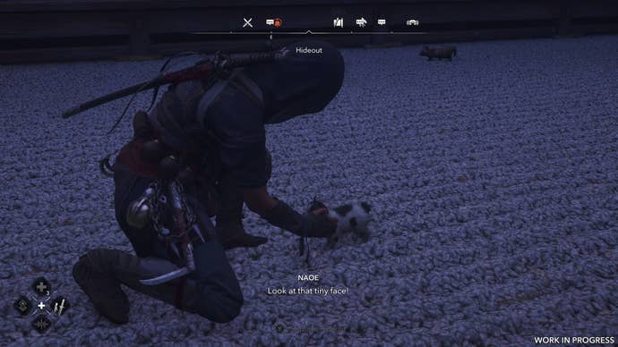 A female shinobi pets a kitten’s belly in Assassin’s Creed Shadows.