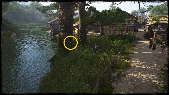 A shot of a tree next to a river in Osaka in Assassin’s Creed Shadows, with a yellow circle highlighting the location of a white Origami Butterfly.