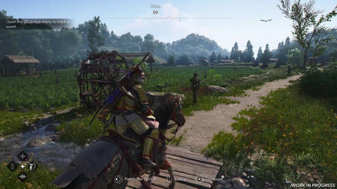 Yasuke rides past a rice field in summer time in Assassin’s Creed Shadows. The plants are larger than they were in spring, obscuring the water.