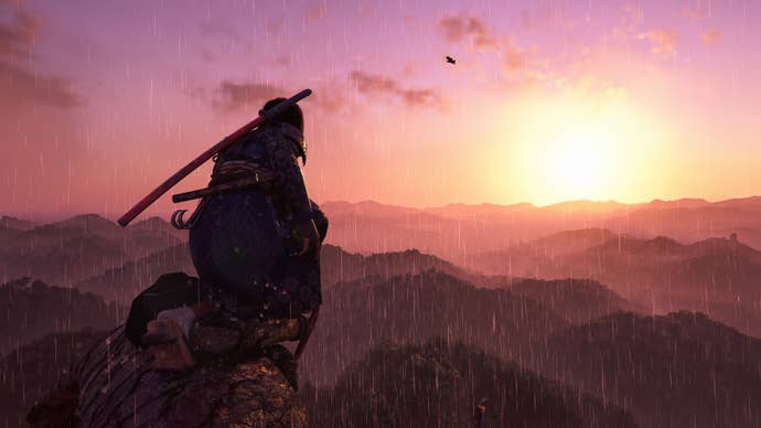 Naoe, the protagonist in Assassin’s Creed Shadows, kneels on the top of a viewpoint on a large tree and looks towards a sunrise over a forest.