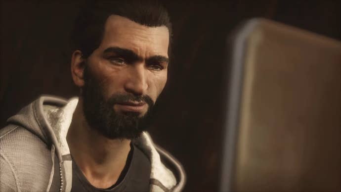 A close-up of Basim, a character in the modern day storyline of Assassin’s Creed Valhalla, staring at a laptop screen.