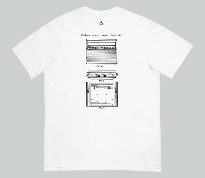The back of a white T-shirt. It has a small Atari logo at the top and the design on the back is a picture of the original Atari Video Computer System patent line art from 1979