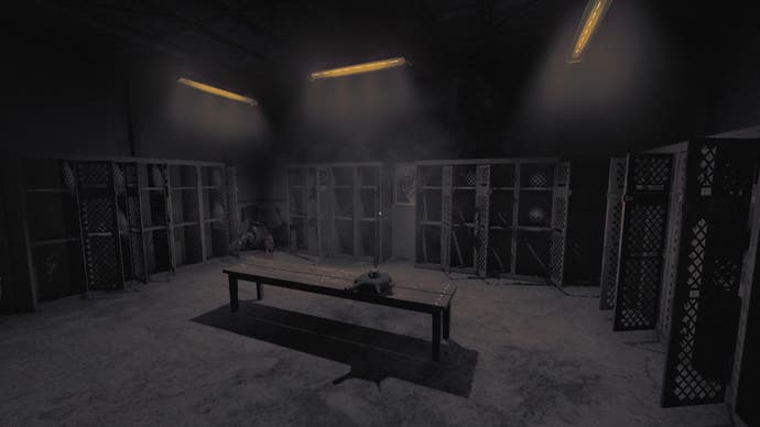 Amnesia: The Bunker review screenshot showing a locker room, where most of the lockers stand open. A body is dumped in the corner of the room, but in the dim light, you can only see it from the chest down.