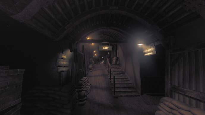 Amnesia: The Bunker review screenshot showing the main thoroughfare of the bunker. A stairway rises into the background, over which a lit EXIT sign shines. A sign to the right says OFFICER QUARTERS / MAINTENANCE whilst the sign on the left says: ARSENAL / SOLDIER’S QUARTERS / ADMINISTRATION