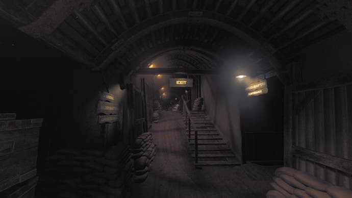 Amnesia: The Bunker review screenshot showing the main thoroughfare of the bunker. A stairway rises into the background, over which a lit EXIT sign shines. A sign to the right says OFFICER QUARTERS / MAINTENANCE whilst the sign on the left says: ARSENAL / SOLDIER'S QUARTERS / ADMINISTRATION