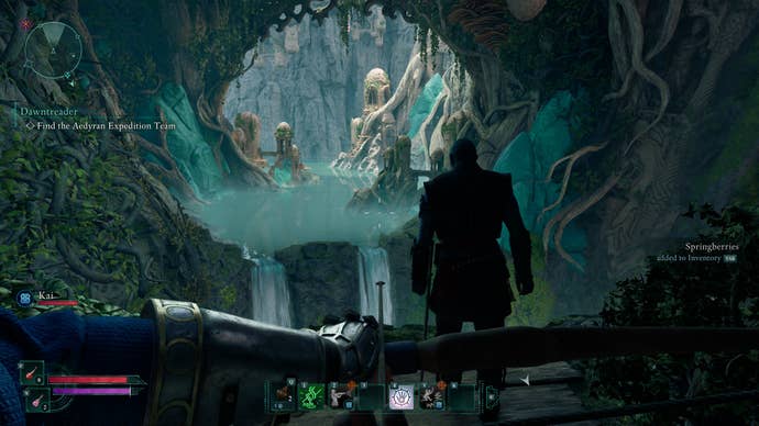 An Avowed screenshot. A first-person viewpoint of a turquoise and green-filled cave, that has a waterfall and stream running through it. It’s fantasy 101, and it’s very appealing.