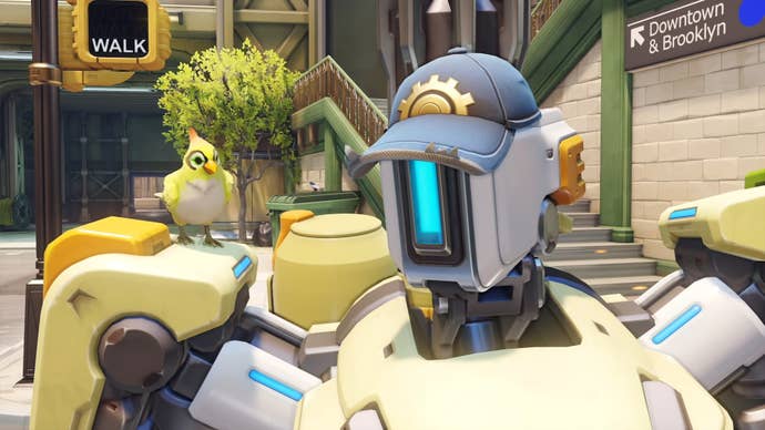 A close-up of Bastion in Overwatch 2, he’s wearing one of Torbjorn’s caps and Ganymede is sat on his shoulder.