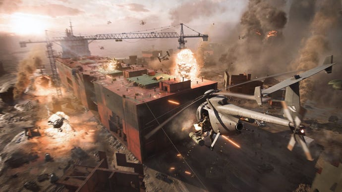 Eine Totalaufnahme, die eine offene Schlacht in Battlefield 2042 zeigt, die auf einem teilweise zerstörten, gestrandeten Frachtschiff stattfindet.  Drohnen, Hubschrauber und Explosionen sind im Spiel