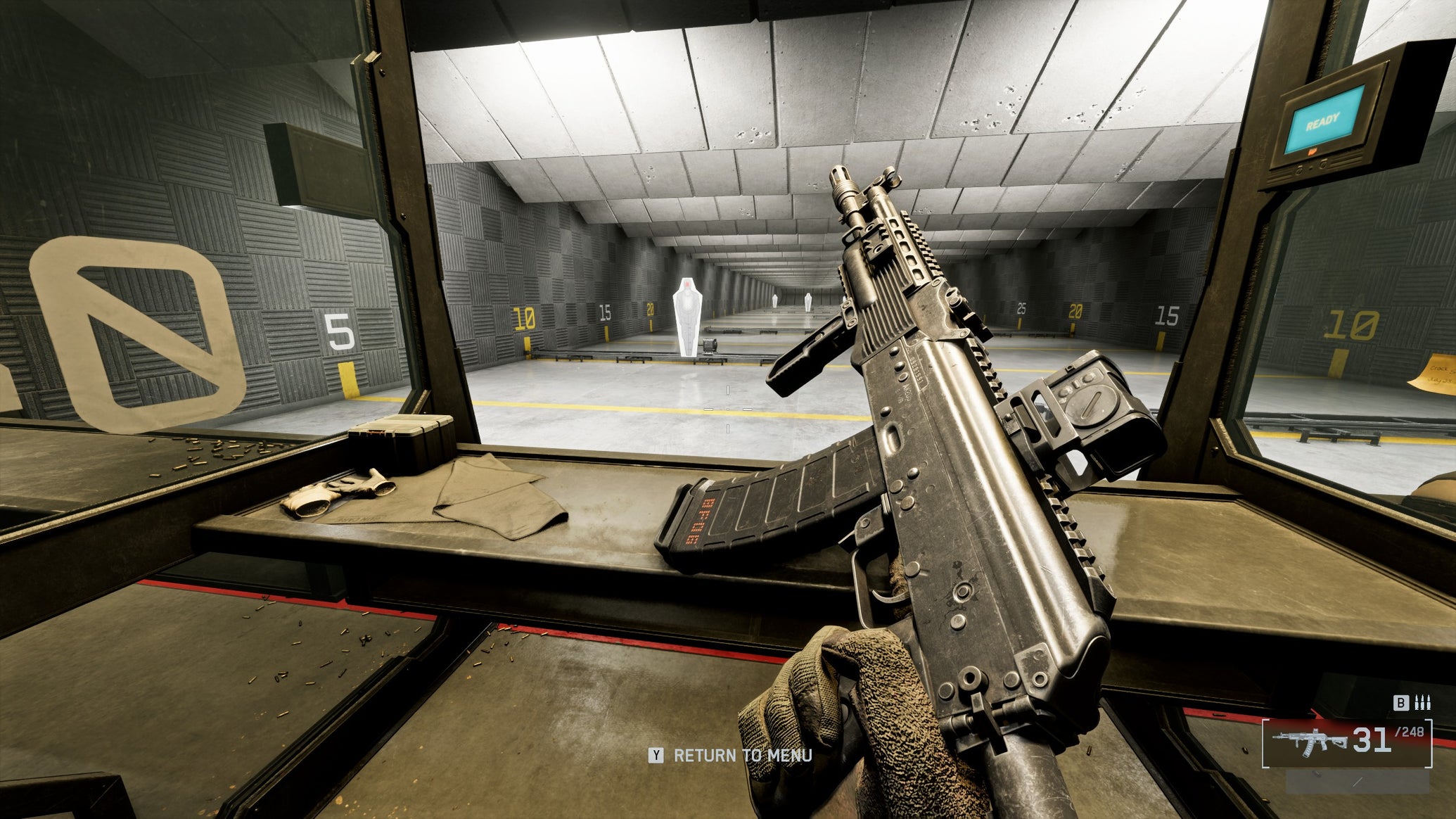 A close-up of the AK-205 carbine in Battlefield 6, with the gun tilted sideways by the player, angling towards the top left of the screen. In the background is a firing range. - 1