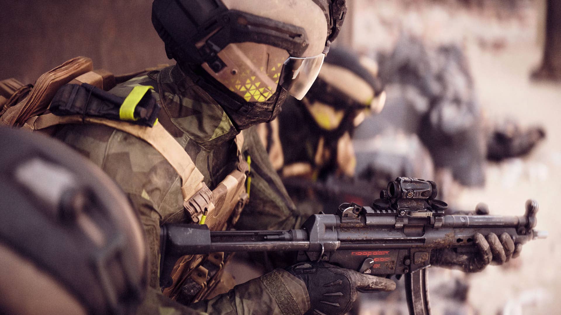 Close up on the upper body - armour and helmet - of a soldier holding an SMG in BF6.