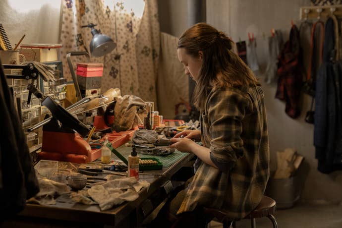 Ellie cleans her gun in the second season of The Last of Us