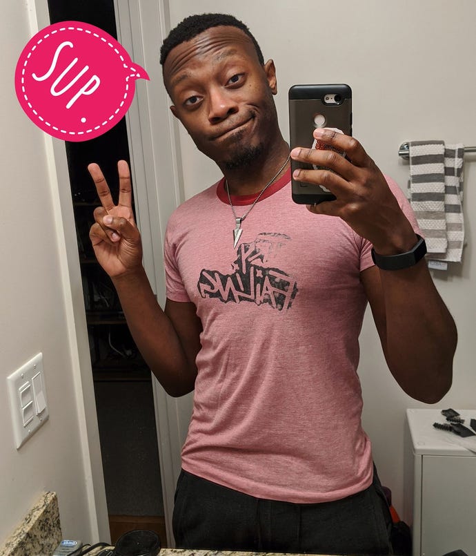 A mirror selfie of the developer Benji Bright, throwing up the peace sign and with an overlaid bright pink speech bubble saying ‘Sup.'