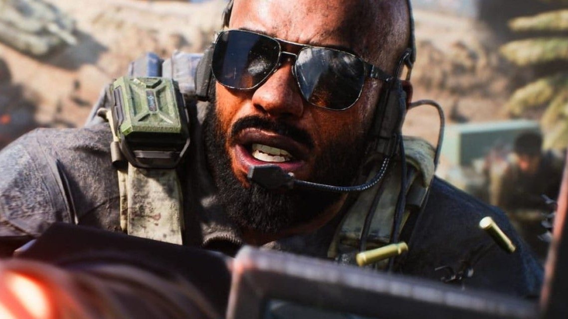 A soldier with sunglasses firing a gun and yelling into a mic in a promotional image for Battlefield 2042. - 1