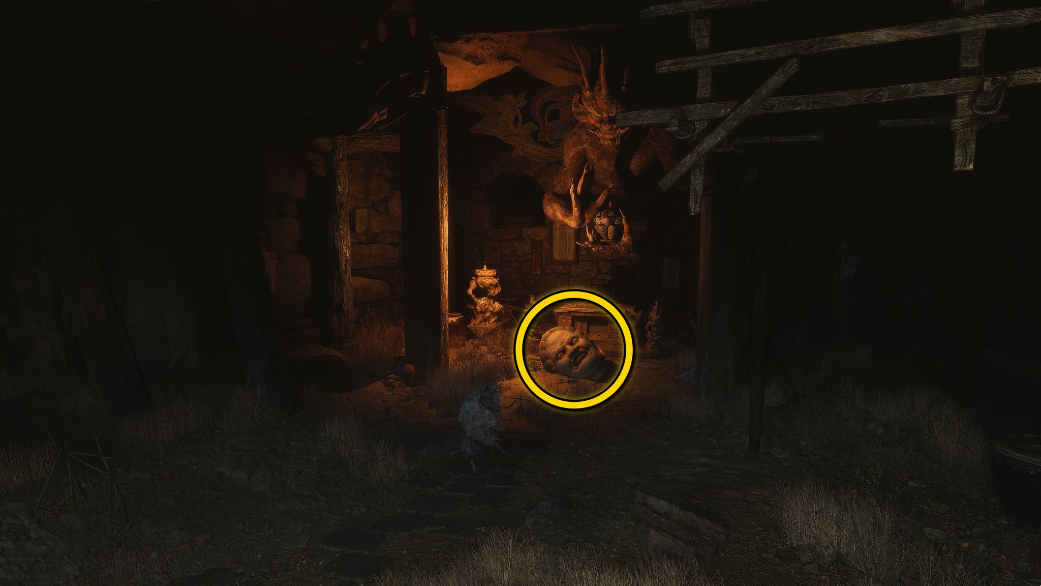 The location of a Buddha head statue on the ground in Fright Cliff, an area in Chapter 2 of Black Myth: Wukong. A yellow circle highlights the position of the Buddha head. - 11