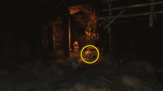 The location of a Buddha head statue on the ground in Fright Cliff, an area in Chapter 2 of Black Myth: Wukong. A yellow circle highlights the position of the Buddha head.