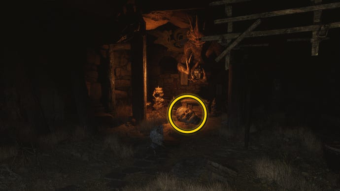 The location of a Buddha head statue on the ground in Fright Cliff, an area in Chapter 2 of Black Myth: Wukong. A yellow circle highlights the position of the Buddha head.