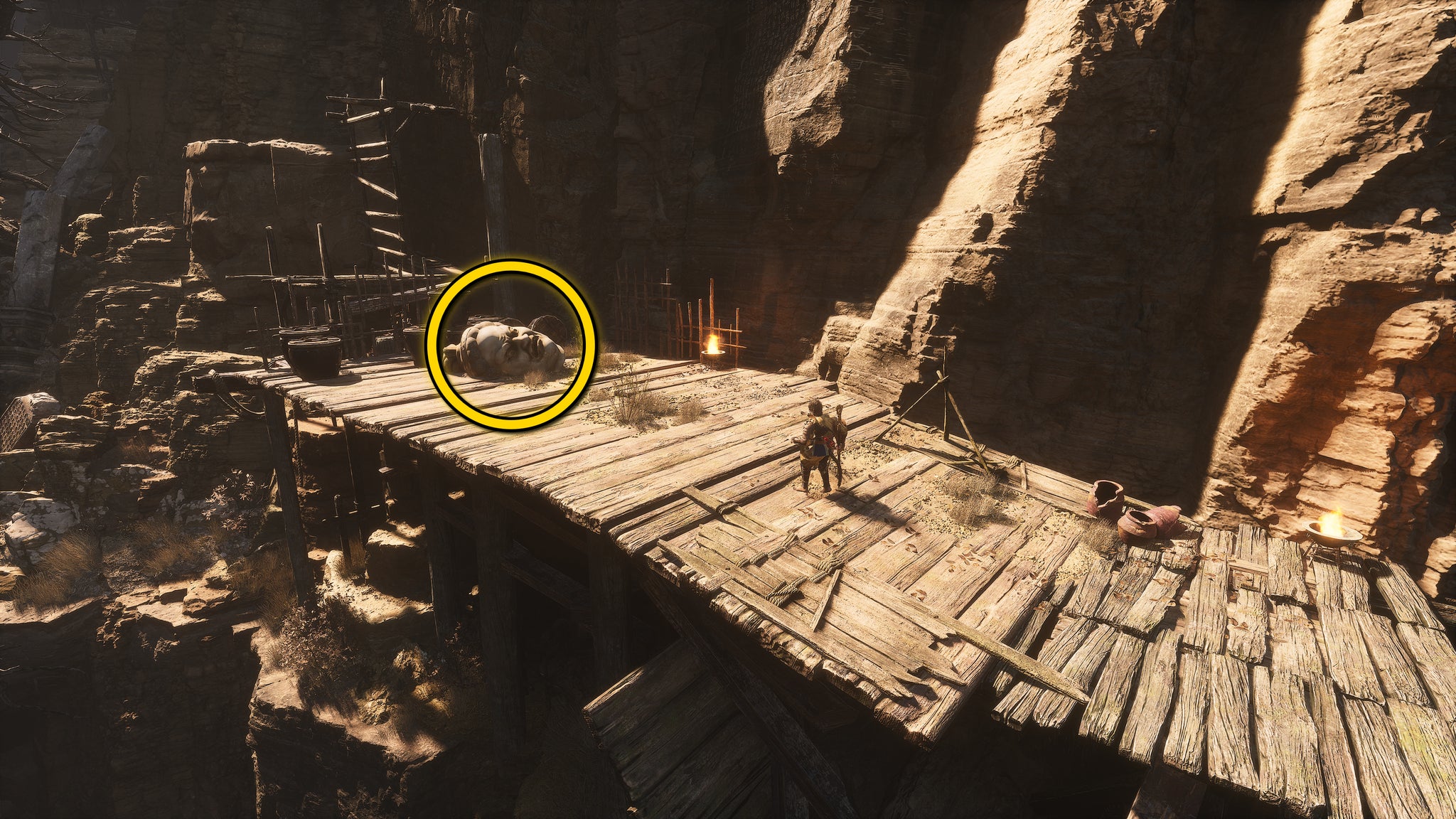 The location of a Buddha head statue on the ground in Fright Cliff, an area in Chapter 2 of Black Myth: Wukong. A yellow circle highlights the position of the Buddha head. - 12