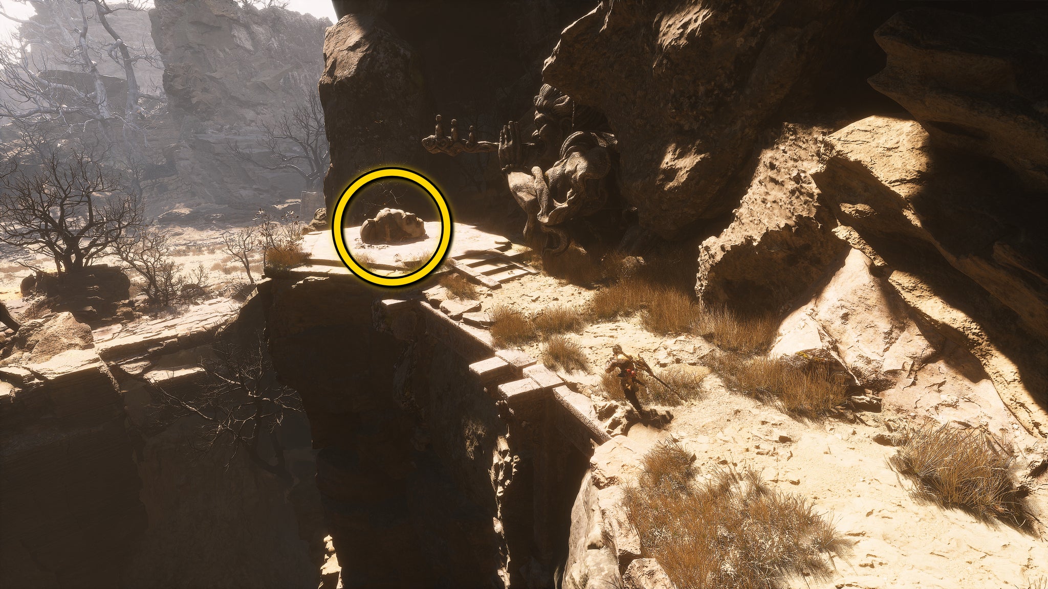 The location of a Buddha head statue on the ground in Fright Cliff, an area in Chapter 2 of Black Myth: Wukong. A yellow circle highlights the position of the Buddha head. - 14