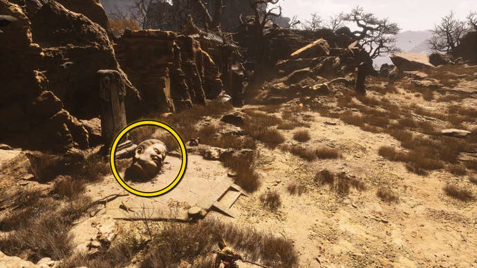 The location of a Buddha head statue on the ground in Fright Cliff, an area in Chapter 2 of Black Myth: Wukong. A yellow circle highlights the position of the Buddha head.