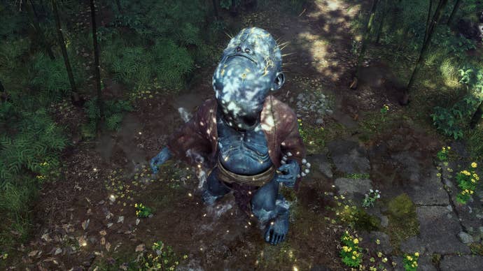 An aerial view of the player in Black Myth: Wukong standing in a forest clearing and transforming into the Spirit of the Wandering Wight boss, a giant blue-skinned creature with an enormous head.