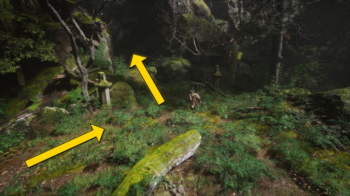 The player in Black Myth: Wukong travels along a path through the Forest Of Wolves in Chapter 1. A yellow arrow points towards the location of the waterfall hiding a secret boss.
