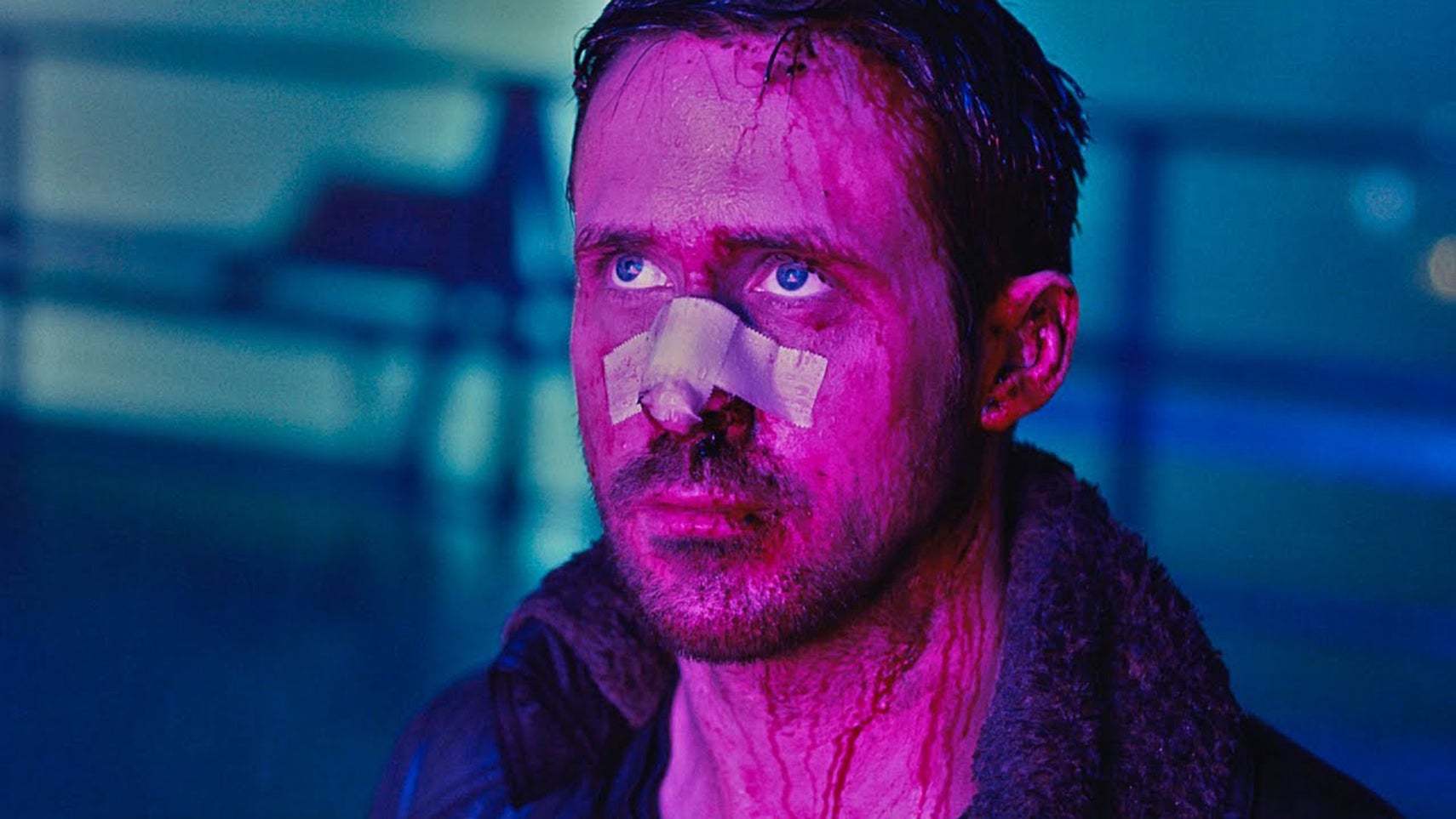 Ryan Gosling in Blade Runner 2049, stood with a bandage across his face, blood streaming down it, bathed in a purple light looking up at something. - 1