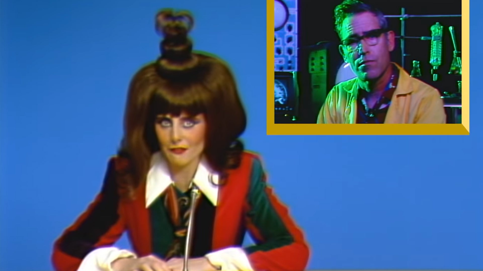 A TV host with a very strange hairstyle talking to a man in a lab superimposed next to her in Blippo+. - 1