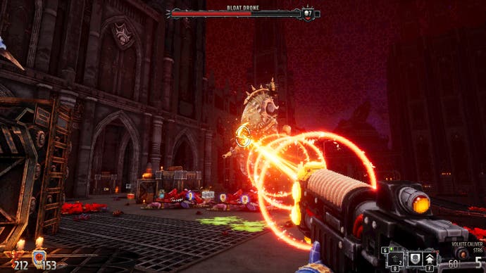 A screenshot from Warhammer 40,000: Boltgun, showing the player attacking a floating Bloat-drone with the Volkite Cavalier's laser beam.