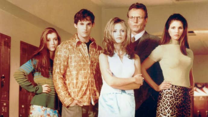The main cast of Buffy the Vampire Slayer all posed in a highschool hallway.