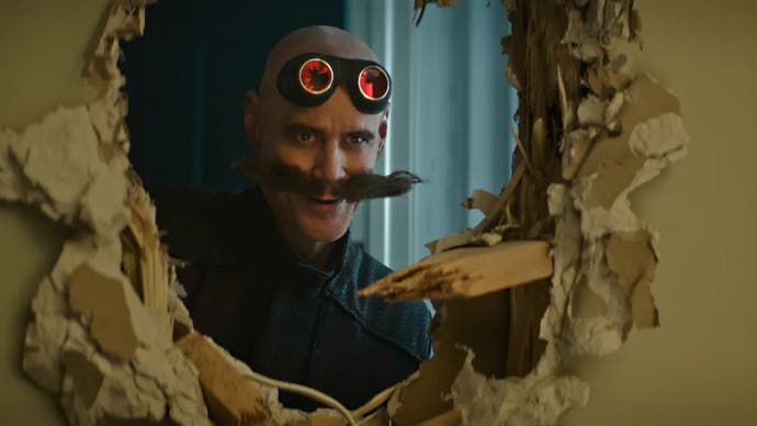 Jim Carrey as Dr Robotnik in Sonic film looking through a hole in a wall
