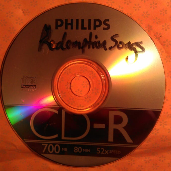 A photograph of a CD-R with the handwritten label ‘Redemption Songs’.