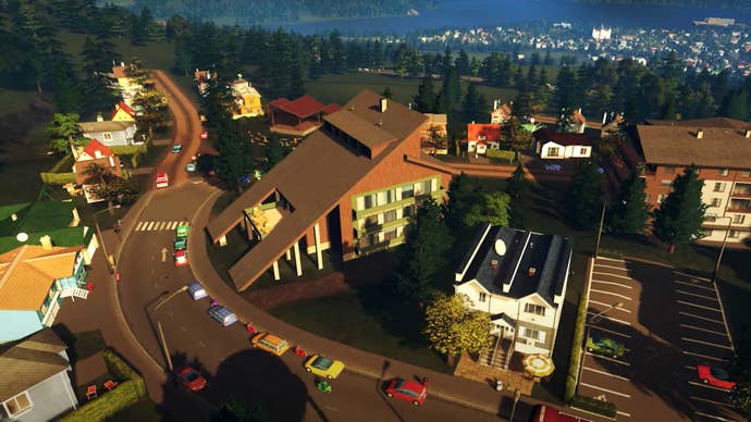 A screenshot of Cities: Skylines' Mountain Village DLC showing an aerial view of Alpine-themed buildings along a winding forest road.