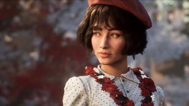 A pretty lady with freckled pale skin and a black bob, wearing a beret and a buttoned-up polka dot blouse. A garland of red flowers hangs around her neck.