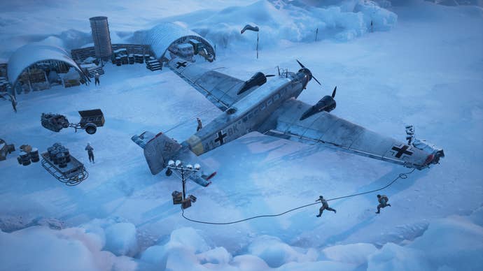 A screenshot for Commandos: Origins, viewed from an isometric perspective, showing the commandos running around a German warplane stationed in a snowy Arctic base.