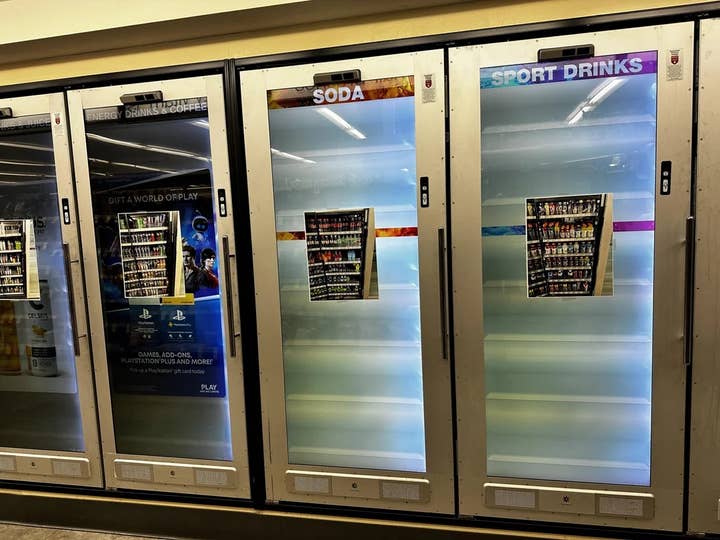 A picture of four Cooler Screens doors that have gone on the fritz. The displays are lit up but they are glitching and not displaying the products, so employees of the store have printed out a large picture of the contents of each cooler, and taped that picture to the front of each door.