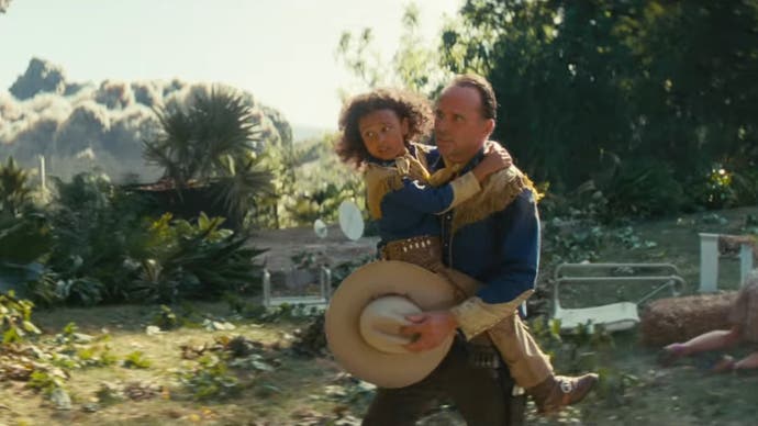 Walton Goggins as Cooper Howard in Amazon's Fallout TV series holding a child as he runs away from an explosion