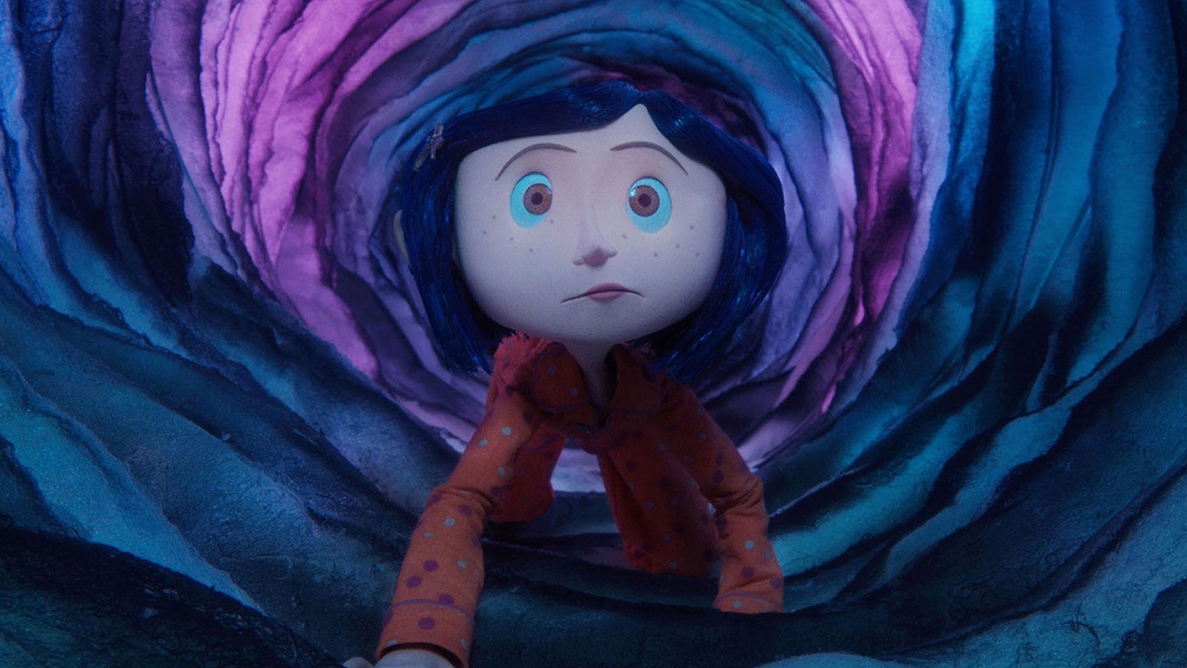 A still from Coraline, showing the titular character wearing pyjamas crawling through a mysterious, slightly glowing, circular cave. - 1