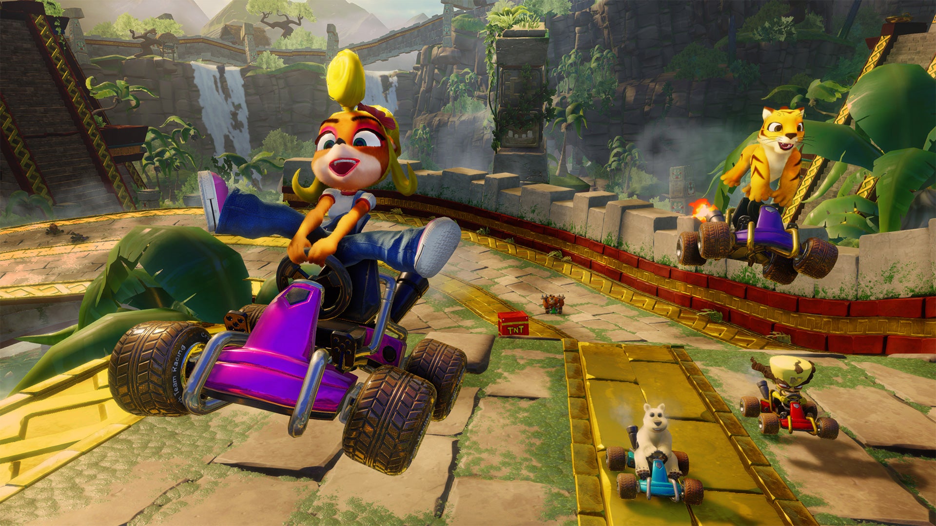 Coco, Pura, Polar and N. Cortex race down a mossy, stone drive in Crash Team Racing Nitro-Fueled.