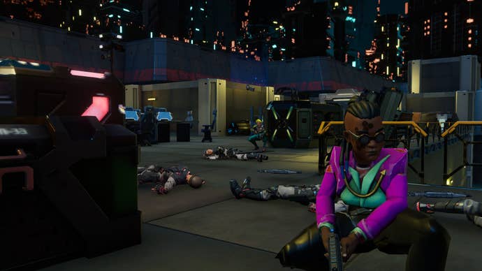 A player crouches down in front of the camera, while dead bodies lay in the background.