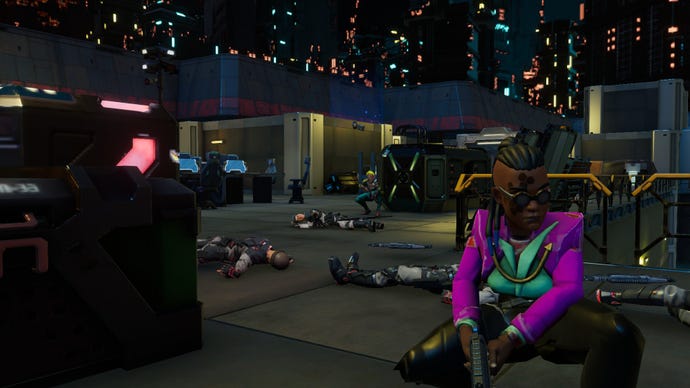 A player crouches down in front of the camera, while dead bodies lay in the background.