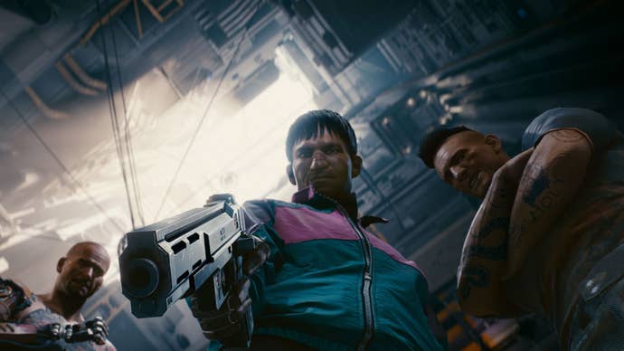 A worm’s eye view of three gang members in Cyberpunk 2077. The middle gang member has a gun drawn and is pointing it downwards towards the camera.